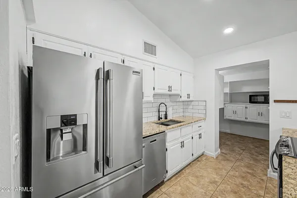 a kitchen with a refrigerator sink and cabinets