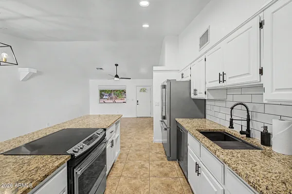a kitchen with stainless steel appliances granite countertop a sink stove and refrigerator