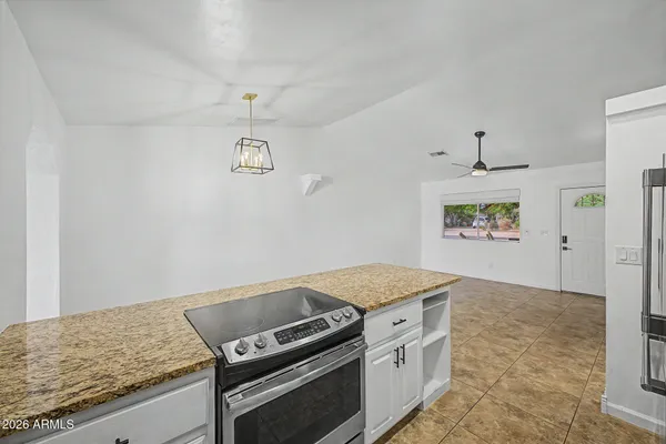 a kitchen with a stove and a granite counter top