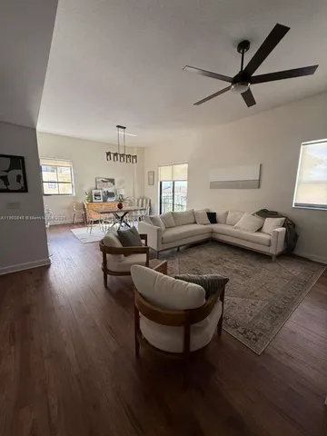 a living room with furniture and a wooden floor