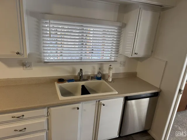 a kitchen with a sink a window and cabinets