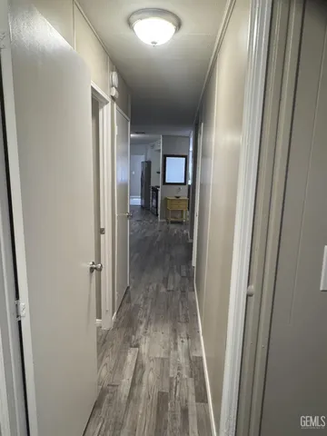 a view of a hallway with wooden floor