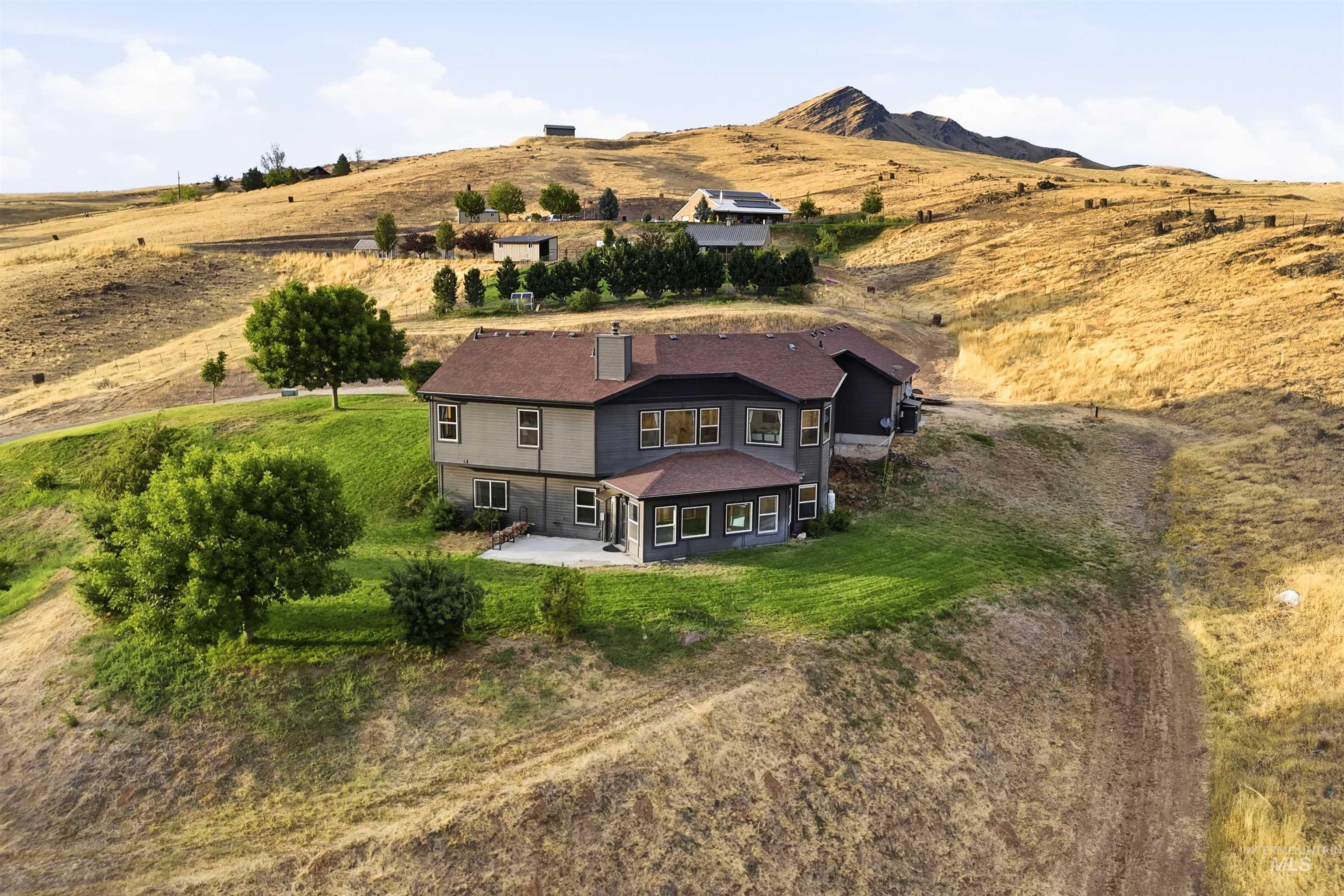 3645 Butte Road Emmett, ID 83617 - Photo 36 of 39 Two-story residence with a covered patio, multiple windows, and a hillside setting