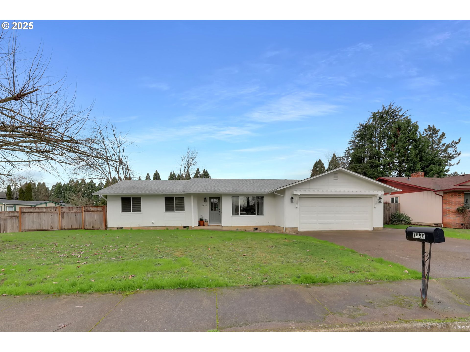 1090 Dixie Drive Springfield, OR 97478 - Photo 2 of 48 a view of a white house next to a yard with big trees