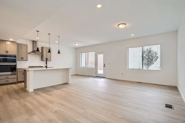 a view of kitchen with kitchen island stainless steel appliances wooden cabinets and window