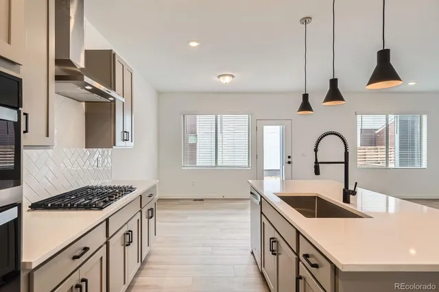 a kitchen with a stove a sink and a refrigerator