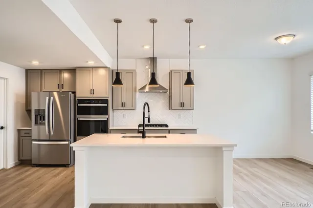 a kitchen with stainless steel appliances a refrigerator sink and microwave