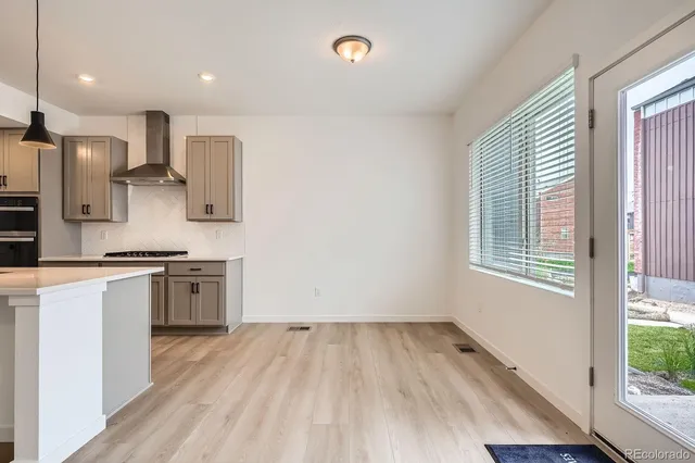 a kitchen with a refrigerator and a stove top oven