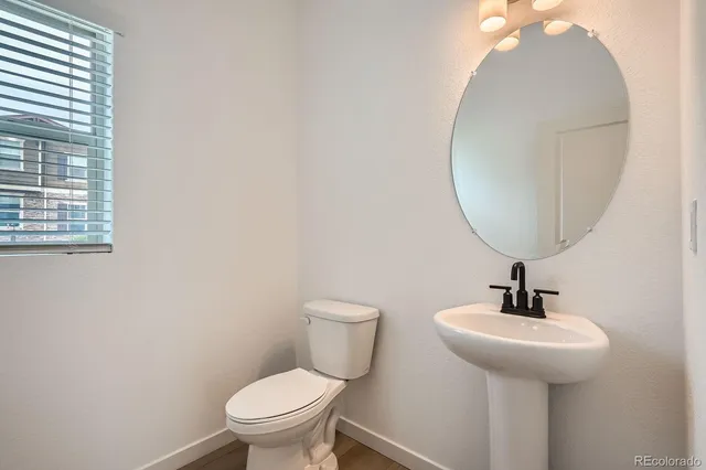 a bathroom with a toilet a sink and mirror