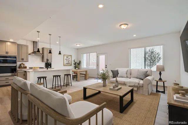 a living room with furniture kitchen view and a window