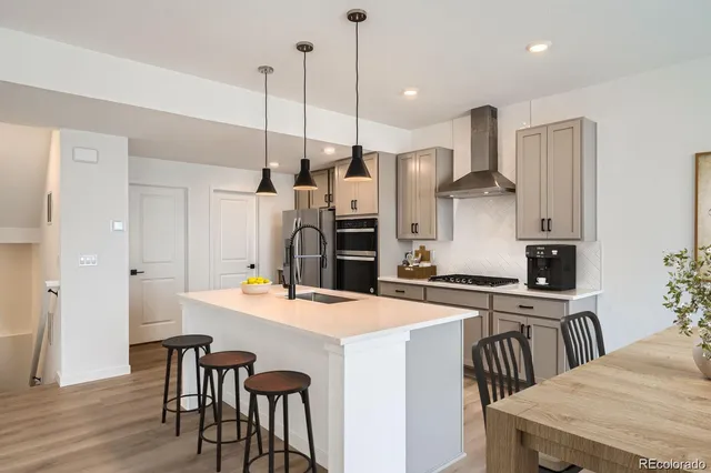 a kitchen that has a table chairs and a refrigerator