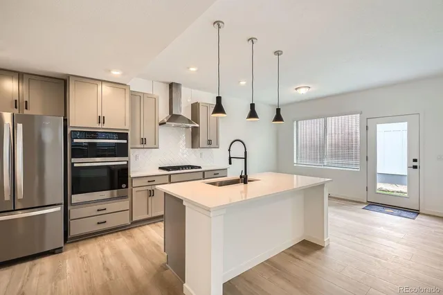 a kitchen with stainless steel appliances granite countertop a sink a stove and a refrigerator