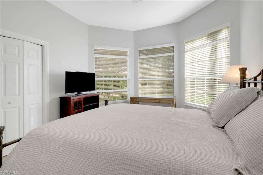 6757 Bent Grass Drive Naples, FL 34113 - Photo 17 of 27 a bedroom with a bed and a flat screen tv