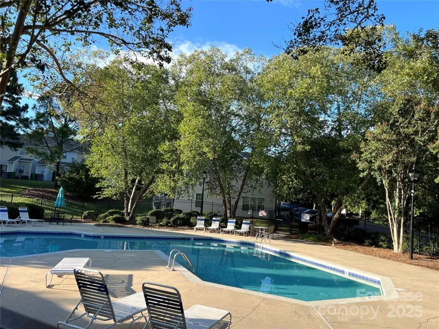 a view of backyard with swimming pool and seating space