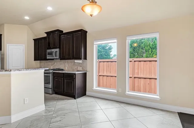 a kitchen with stainless steel appliances granite countertop a stove a sink and a microwave oven