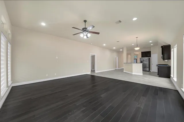 wooden floor in an empty room with a kitchen