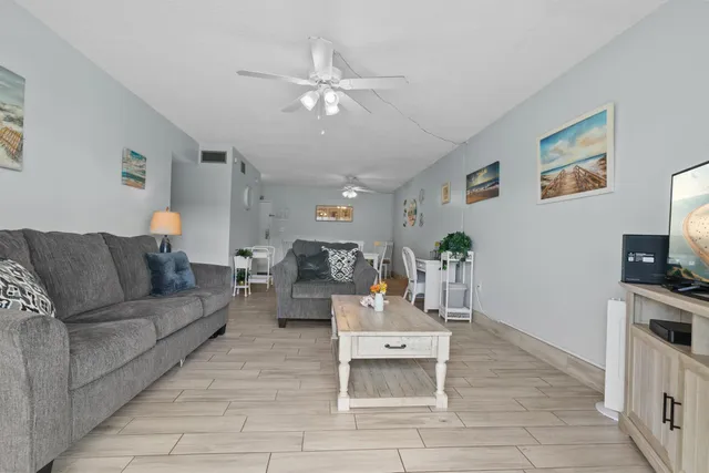 a view of a dining room with furniture and a chandelier fan