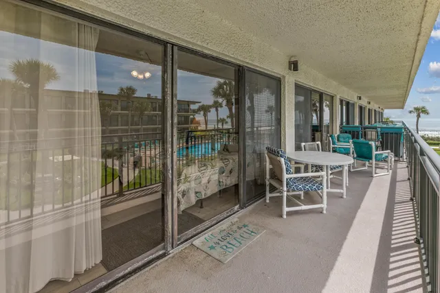 a balcony with tall trees in front of it