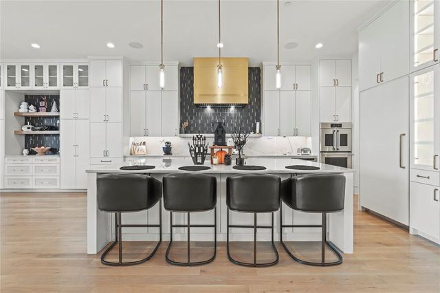 a kitchen with kitchen island granite countertop a sink and a refrigerator