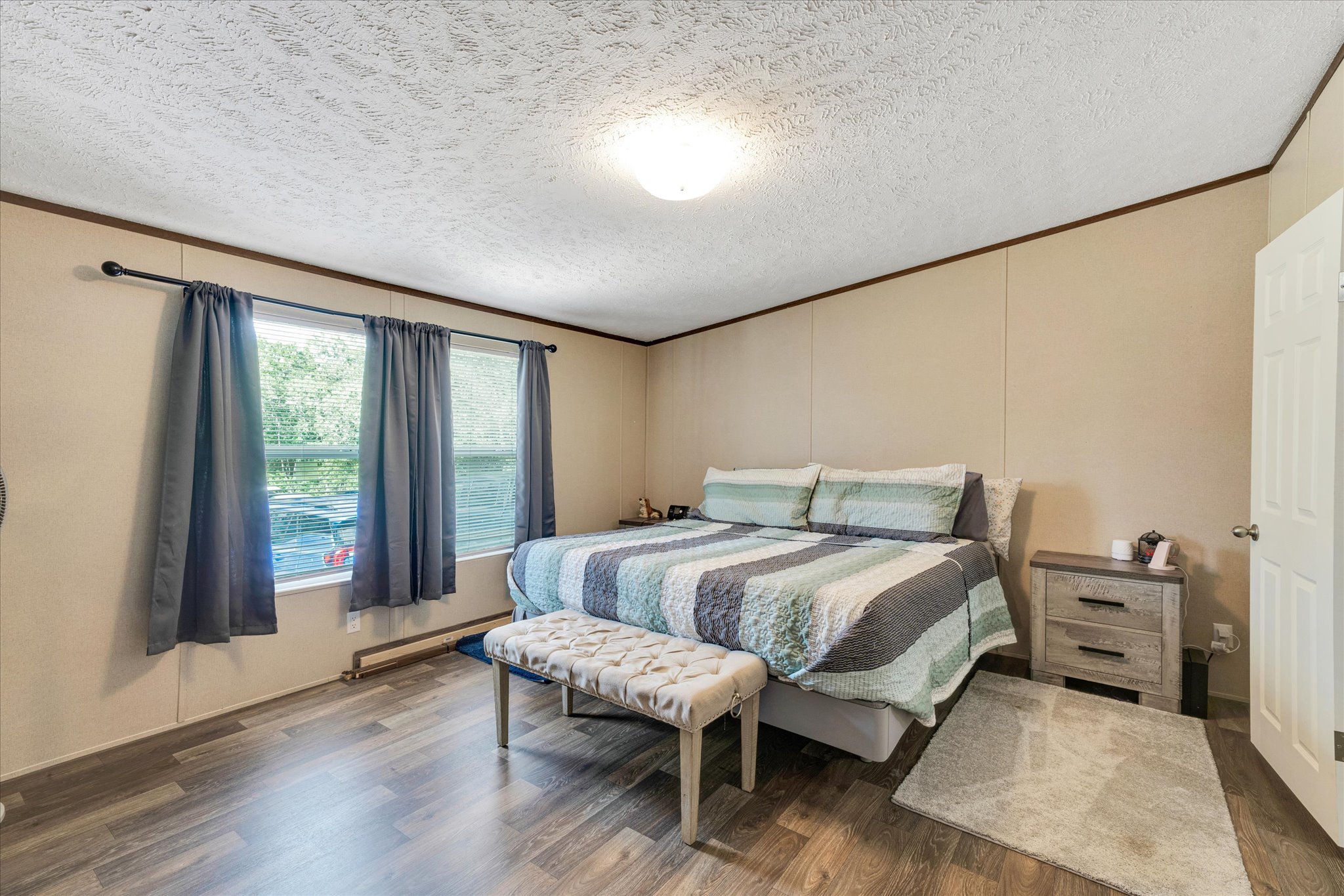 2755 Washburn Road Luling, TX 78648 - Photo 13 of 40 Wood-look flooring and multiple windows enhance this peaceful bedroom retreat.
