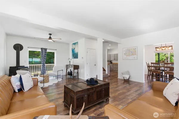 a living room with furniture large window and dining table