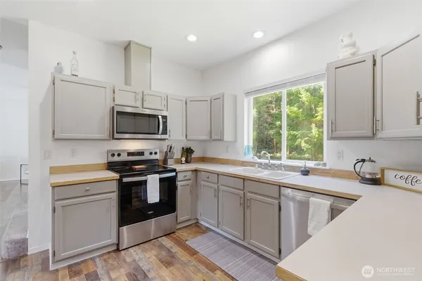 a kitchen with stainless steel appliances a sink stove and microwave
