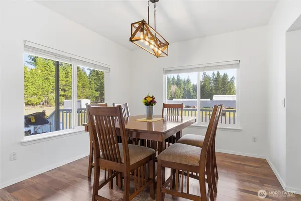 a view of a dining room with furniture a chandelier and wooden floor