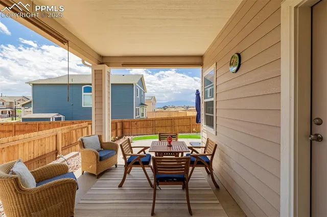 a view of a roof deck with table and chairs a barbeque with wooden floor and fence