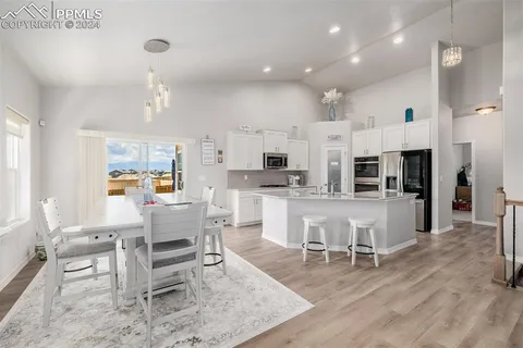 a living room with stainless steel appliances kitchen island furniture and a view of kitchen