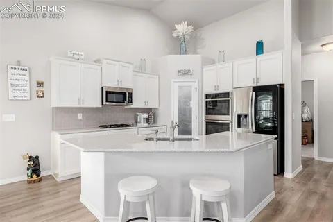 a large kitchen with kitchen island a sink counter space and appliances