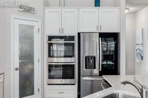 a kitchen with stainless steel appliances granite countertop a refrigerator and a stove