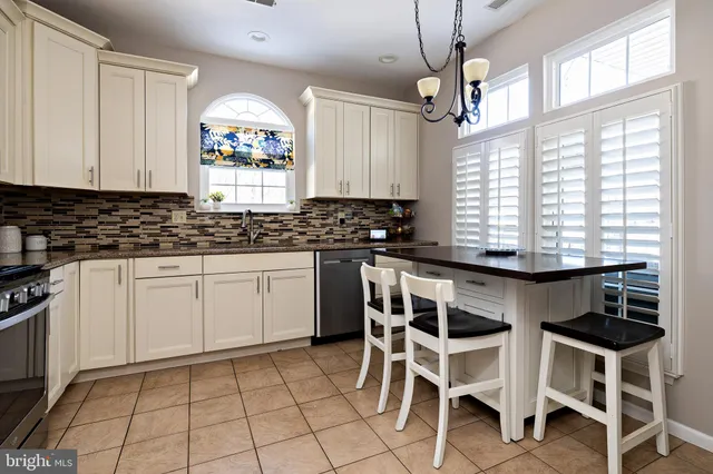 a dining room with wooden floor a chandelier a wooden table and chairs