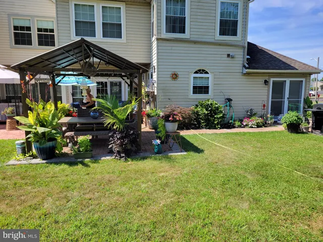 a view of a house with a yard and sitting area
