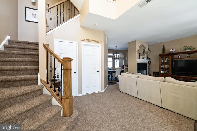 a living room with furniture a flat screen tv and a refrigerator