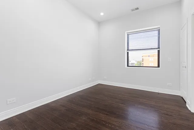 an empty room with wooden floor and a window