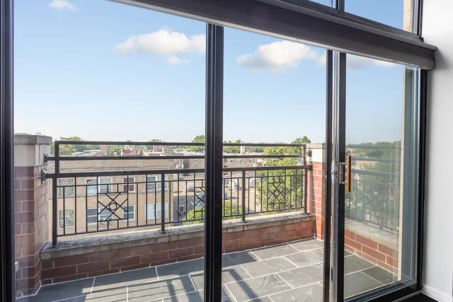 a view of a balcony with floor to ceiling windows with wooden floor