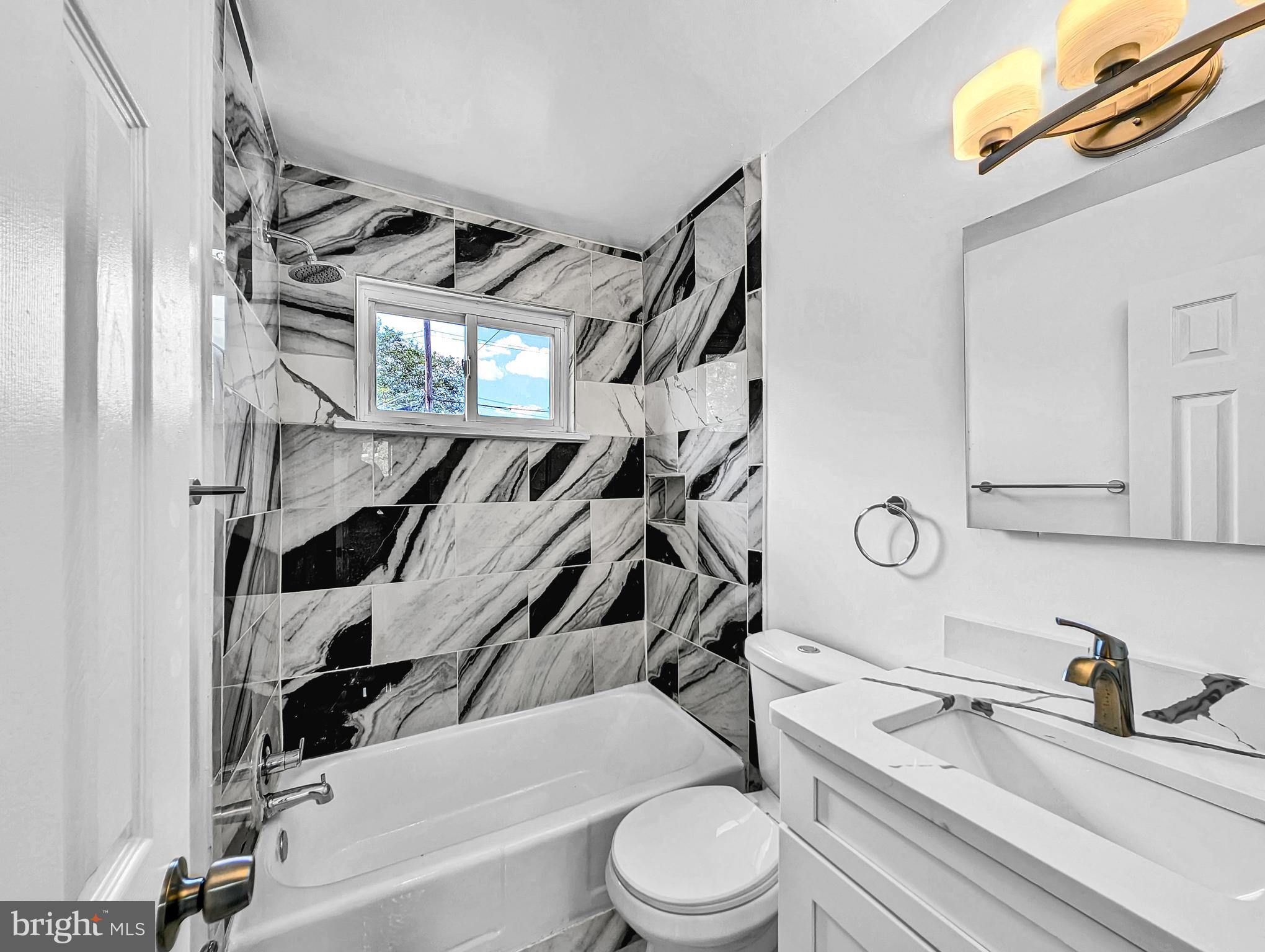 2240 15th Street Northeast Washington, DC 20018 - Photo 17 of 22 a bathroom with a granite countertop bathtub sink vanity mirror and toilet