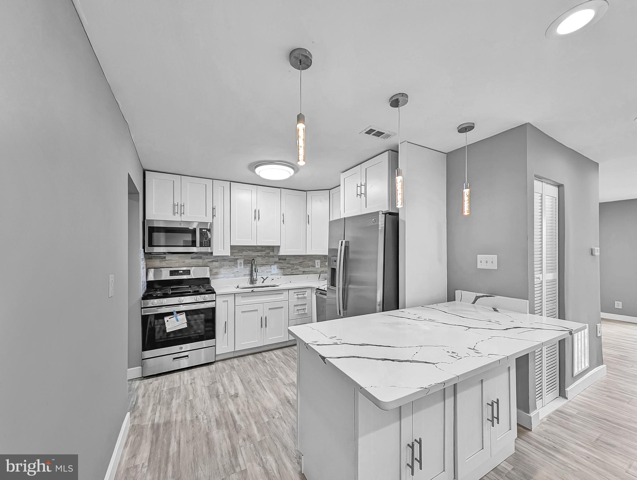 2240 15th Street Northeast Washington, DC 20018 - Photo 5 of 22 a kitchen with stainless steel appliances kitchen island granite countertop a sink stove and refrigerator