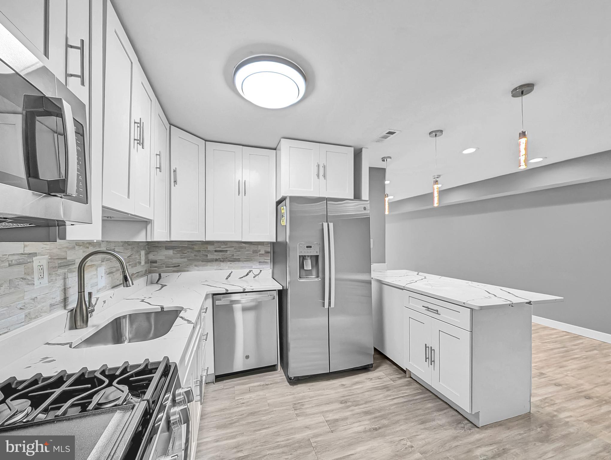 2240 15th Street Northeast Washington, DC 20018 - Photo 6 of 22 a kitchen with stainless steel appliances granite countertop a sink stove and refrigerator