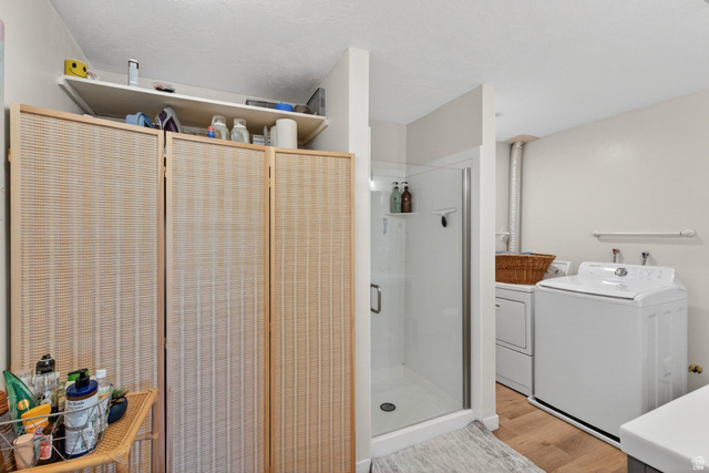 380 Luzern Road Midway, UT 84049 - Photo 54 of 74 Three-panel room divider with shelving, a glass-enclosed shower, wood-finish flooring, and a dedicated laundry area with hookups