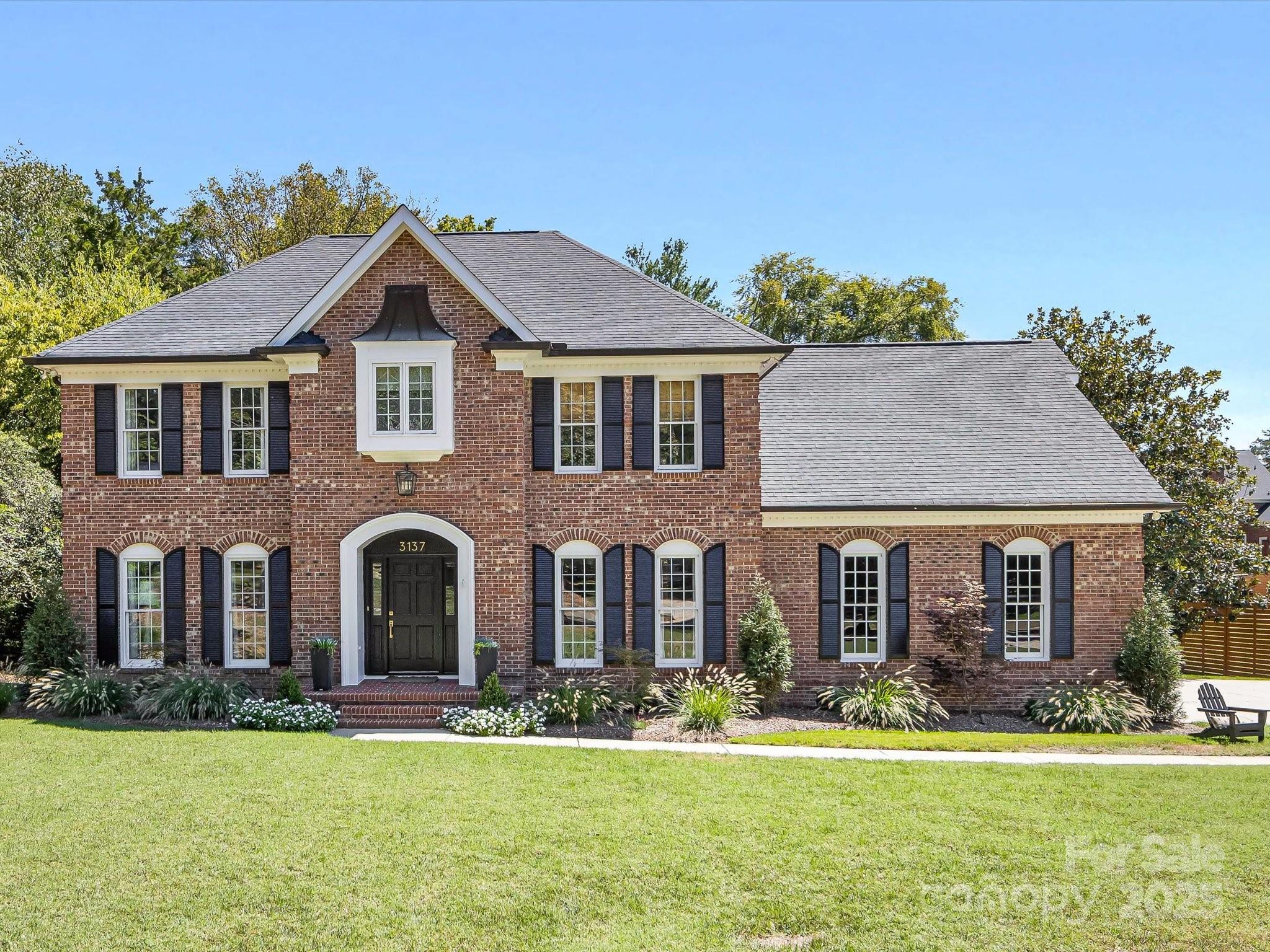 front view of a brick house next to a yard