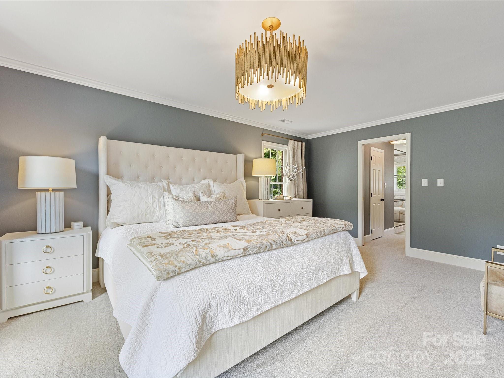 3137 Broadfield Road Charlotte, NC 28226 - Photo 18 of 42 a bedroom with a bed and a chandelier