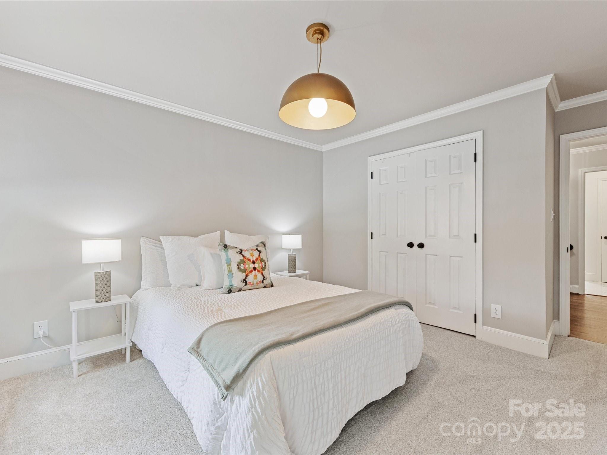3137 Broadfield Road Charlotte, NC 28226 - Photo 25 of 42 a bedroom with a bed and a chandelier