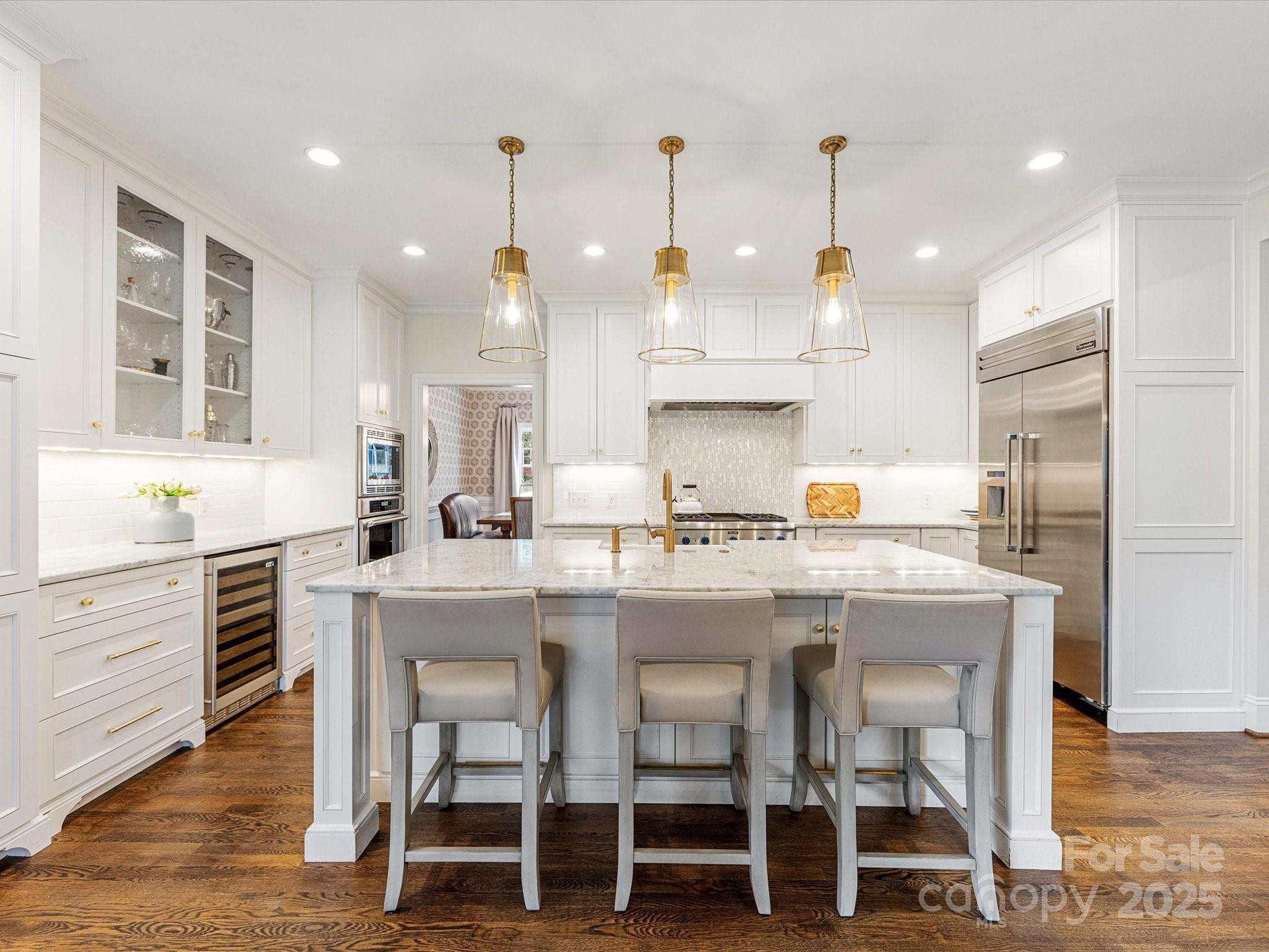 3137 Broadfield Road Charlotte, NC 28226 - Photo 4 of 42 a kitchen with kitchen island granite countertop a table chairs sink and cabinets