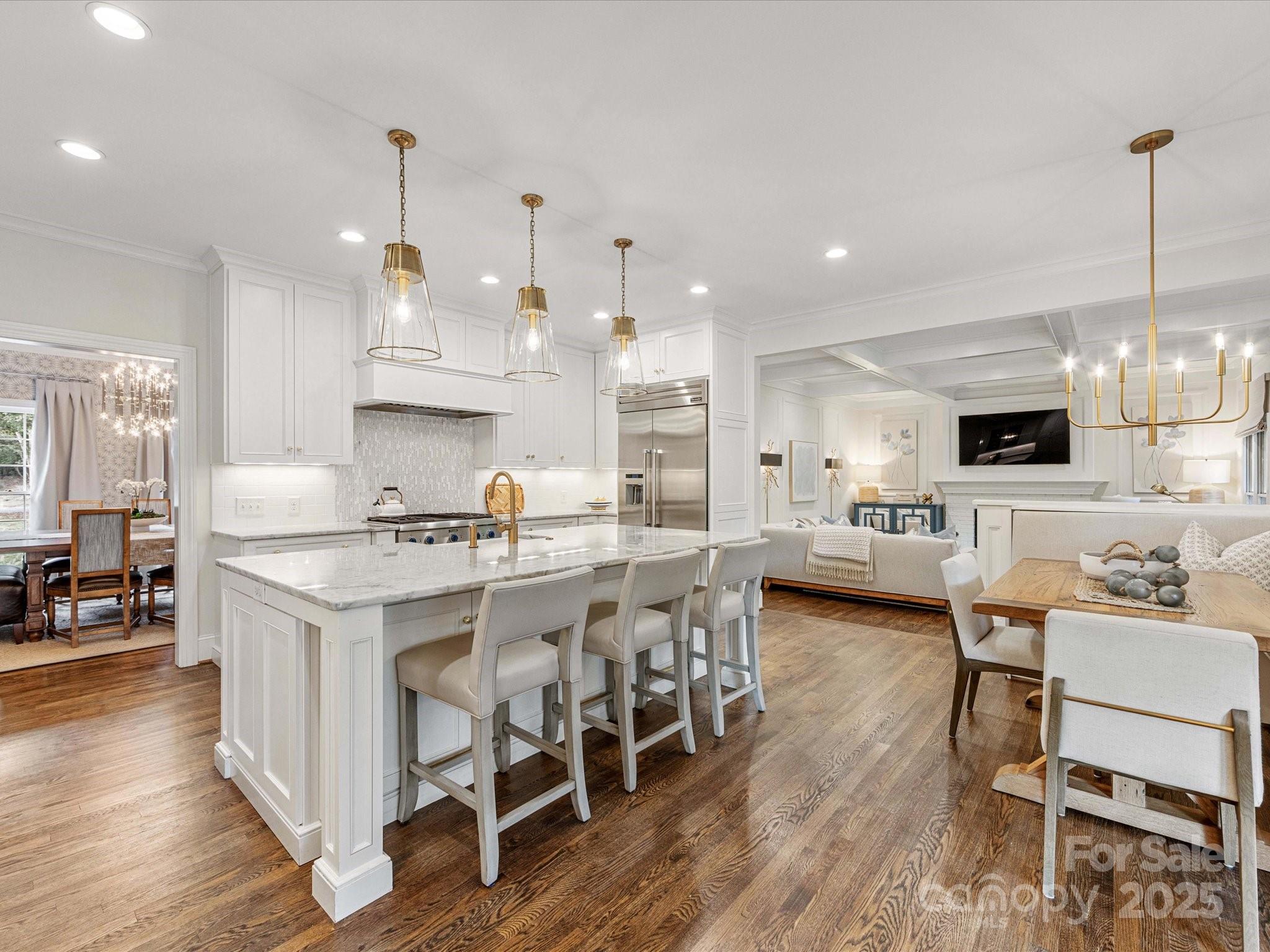 3137 Broadfield Road Charlotte, NC 28226 - Photo 6 of 42 a kitchen with stainless steel appliances kitchen island granite countertop a wooden floor and white cabinets