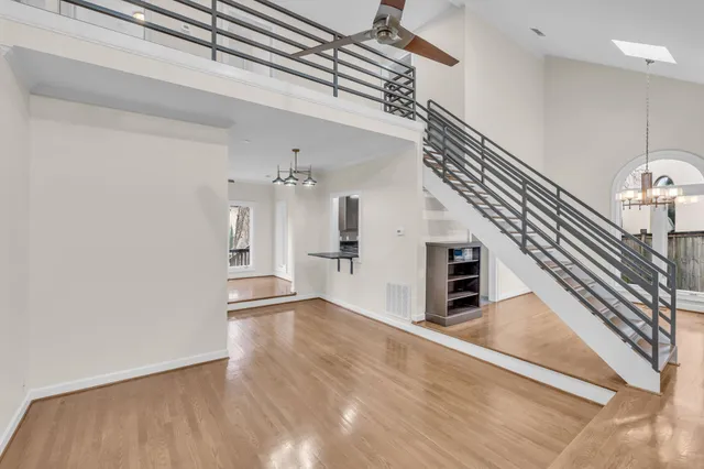a view of a hallway with wooden floor and staircase