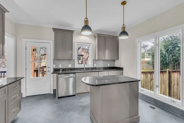 a kitchen with stainless steel appliances granite countertop a sink a stove and a wooden floors