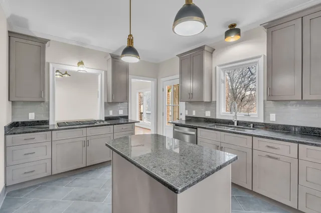 a kitchen with center island a sink stainless steel appliances and cabinets