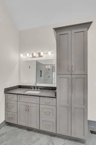 a bathroom with a granite countertop sink and a mirror