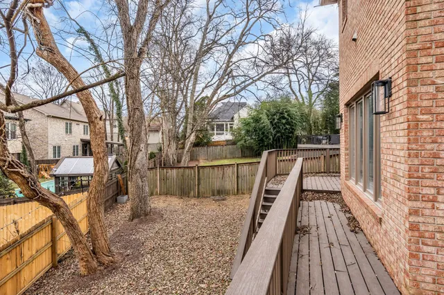 a view of house with backyard and trees
